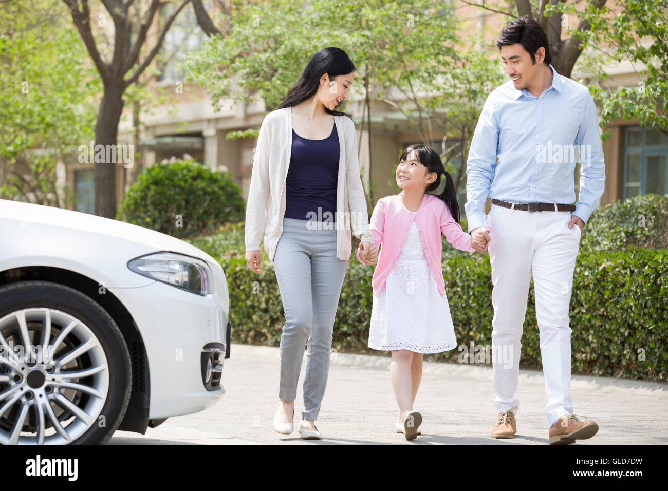 Happy young Chinese family holding hands walking Stock Photo - Alamy