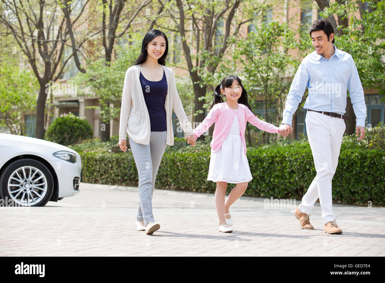 Happy young Chinese family holding hands walking Stock Photo - Alamy