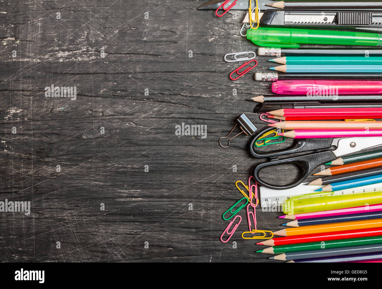 School supplies on blackboard background, top view, copy space Stock