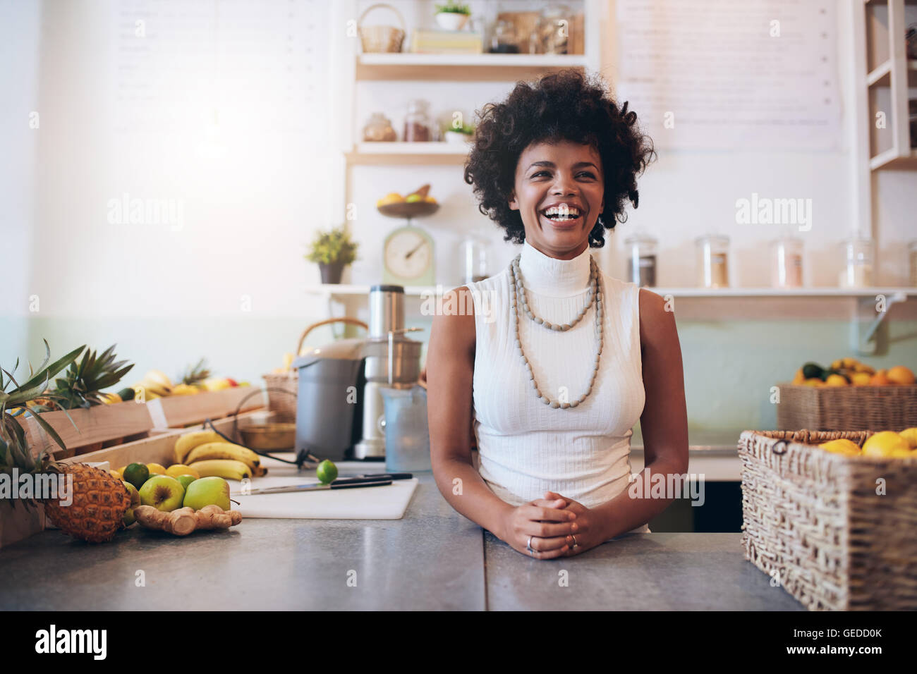 Portrait of young african woman standing behind juice bar counter