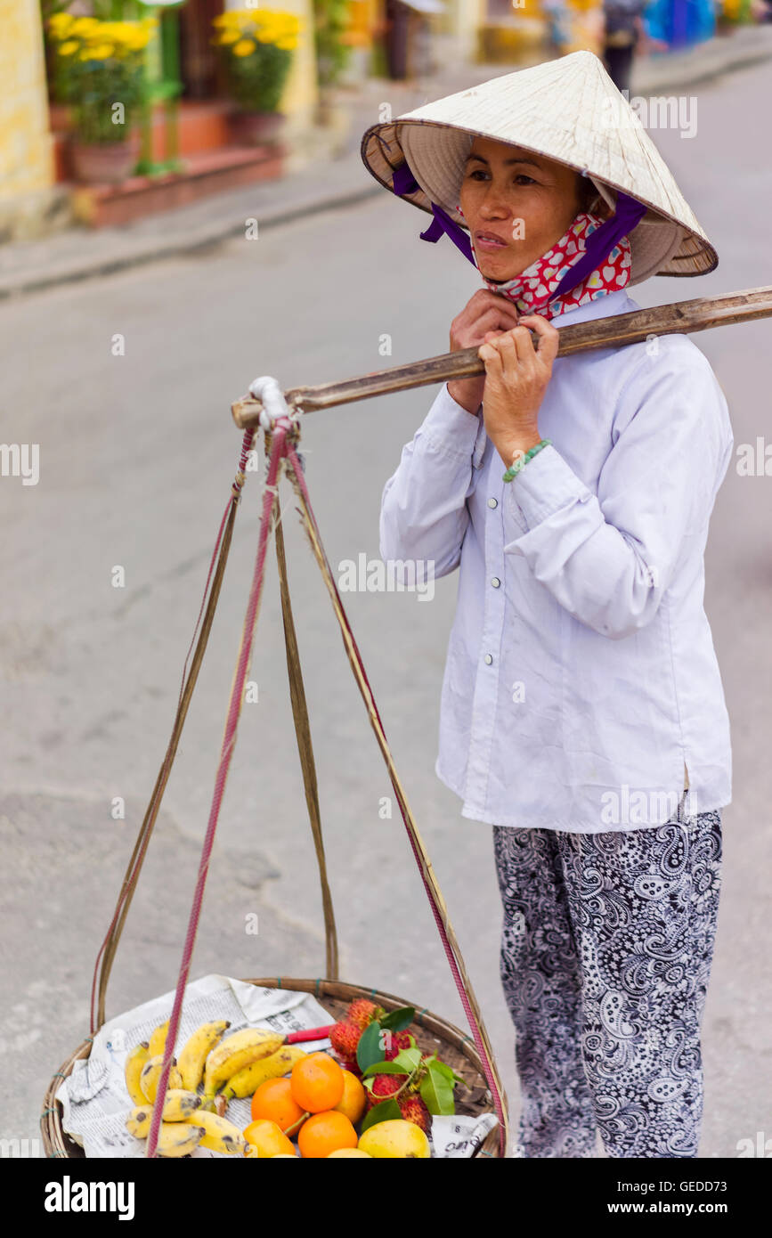 Hoi An, Vietnam February 16, 2016 Asian trader carrying fresh fruit