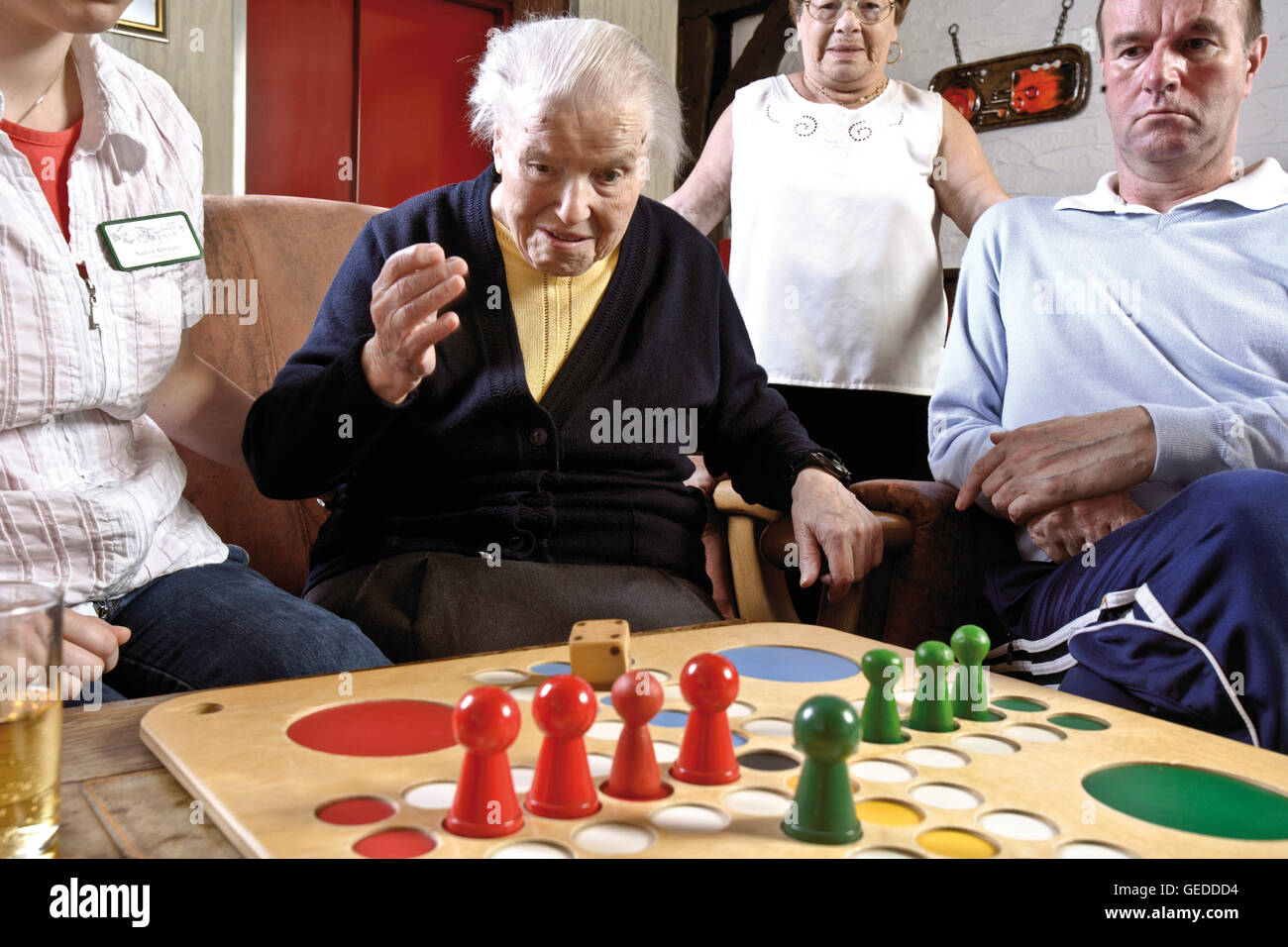 Nurses and residents of an old-age home or nursing home playing board games in the afternoon Stock Photo