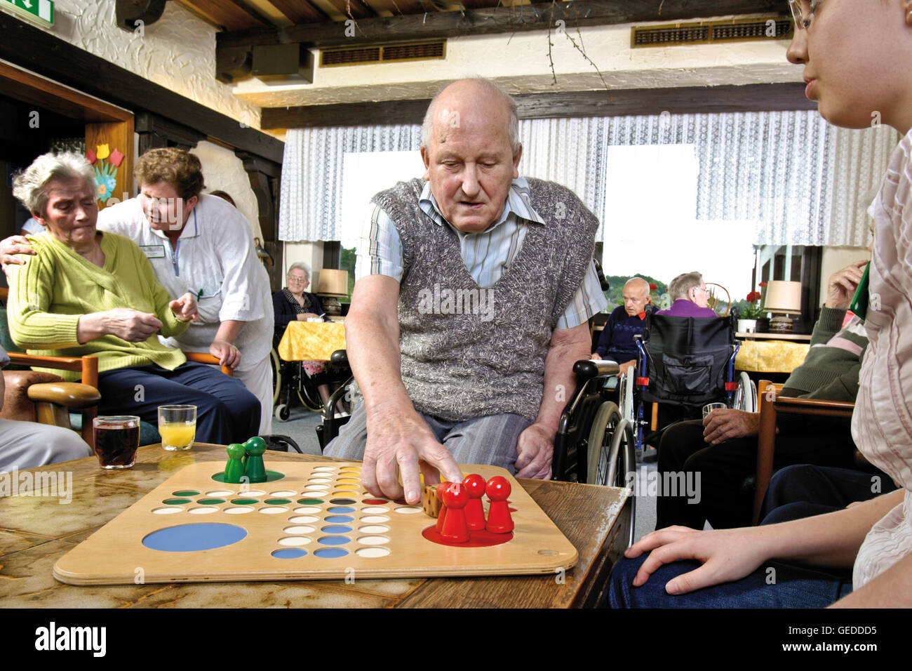 Residents and nurses playing board games at a nursing home Stock Photo
