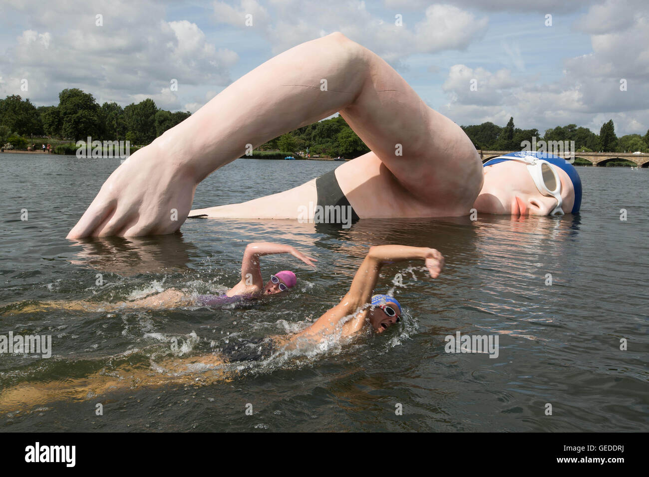 Sarah-Kate Berlyn (left) and George Cselko swim past a 12ft x 40ft sculpture of British swimming champion Rebecca Adlington after it was unveiled in The Serpentine in London&Atilde;&shy;s Hyde Park, as part of the Kellogg&Atilde;&shy;s #GreatStarts Olympic campaign, to encourage the public to support Team GB at Rio 2016 Olympics. Stock Photo