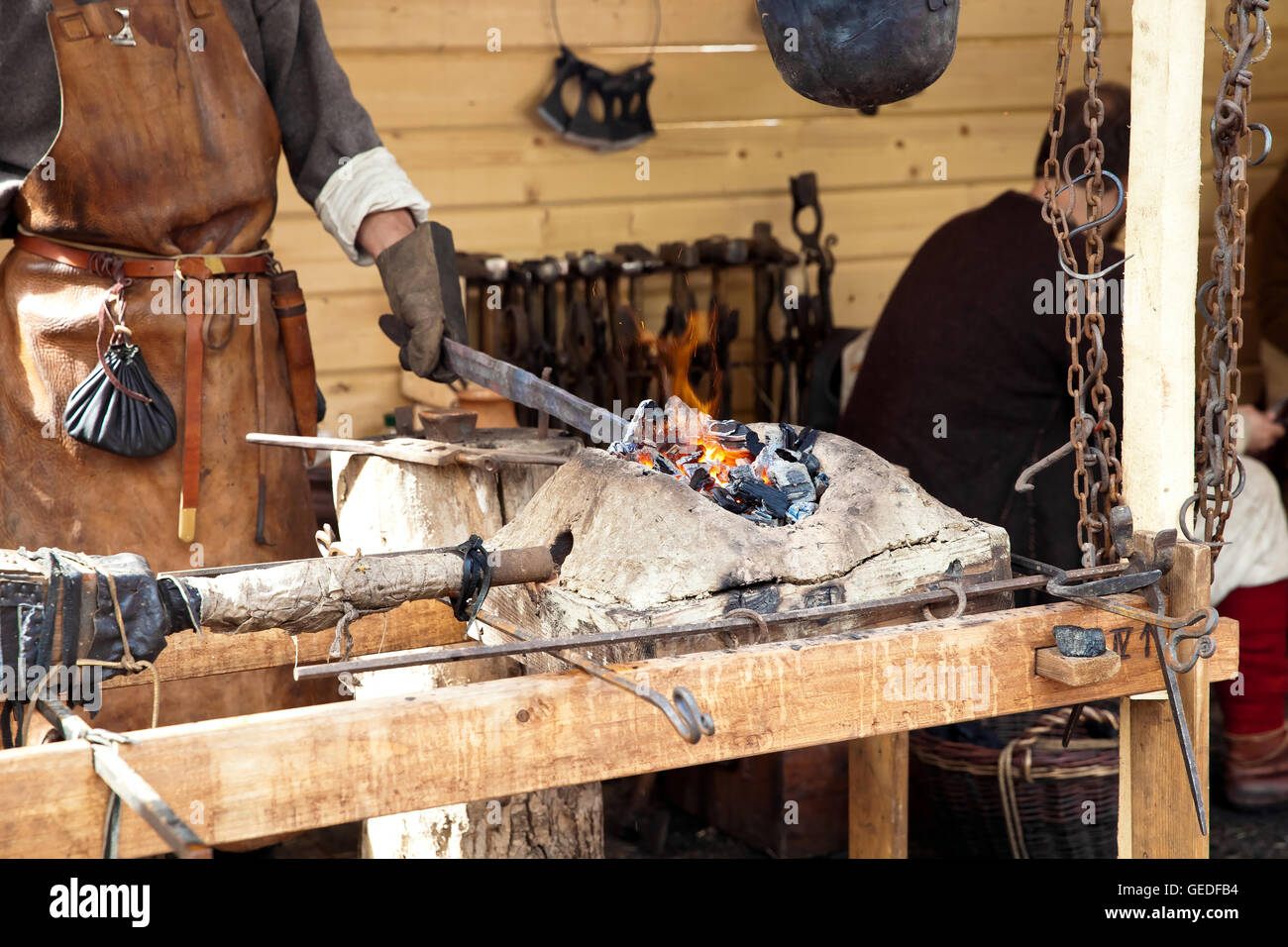 Blacksmith blows the bellows Stock Photo