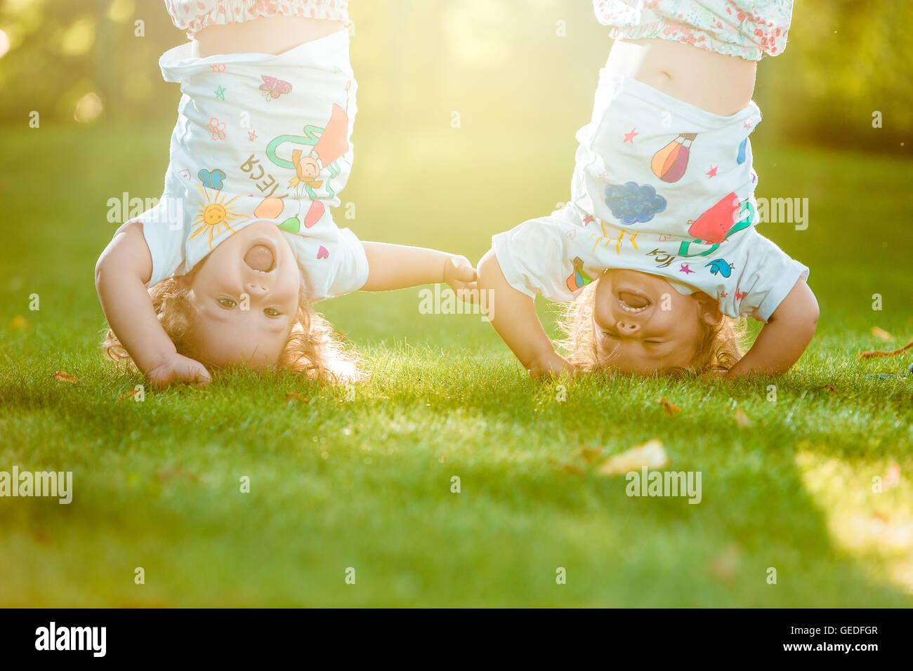 The two little baby girls hanging upside down Stock Photo Alamy