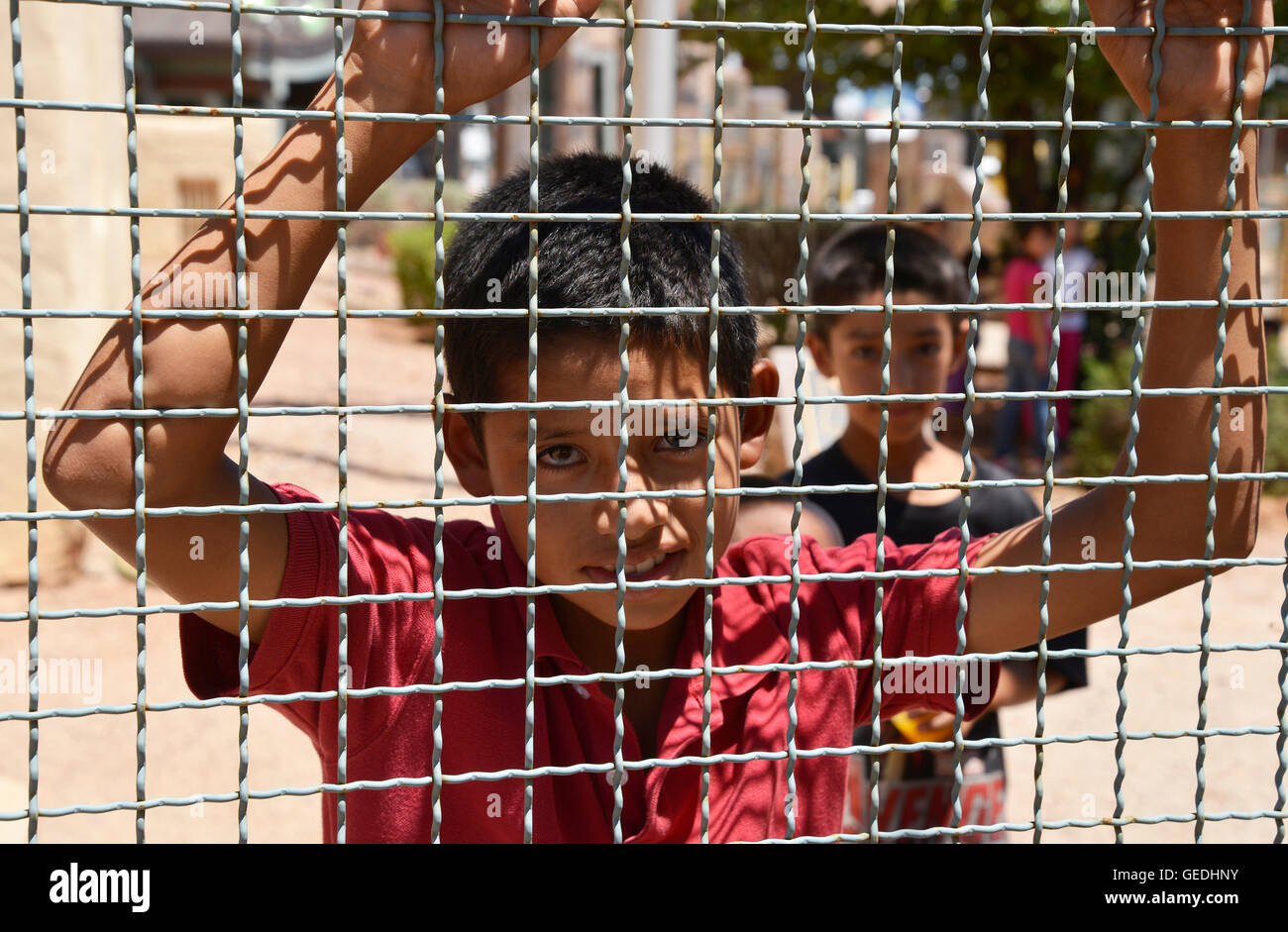 A boy looks into Arizona from Mexico at the border between Naco, Arizona, USA and Naco, Sonora