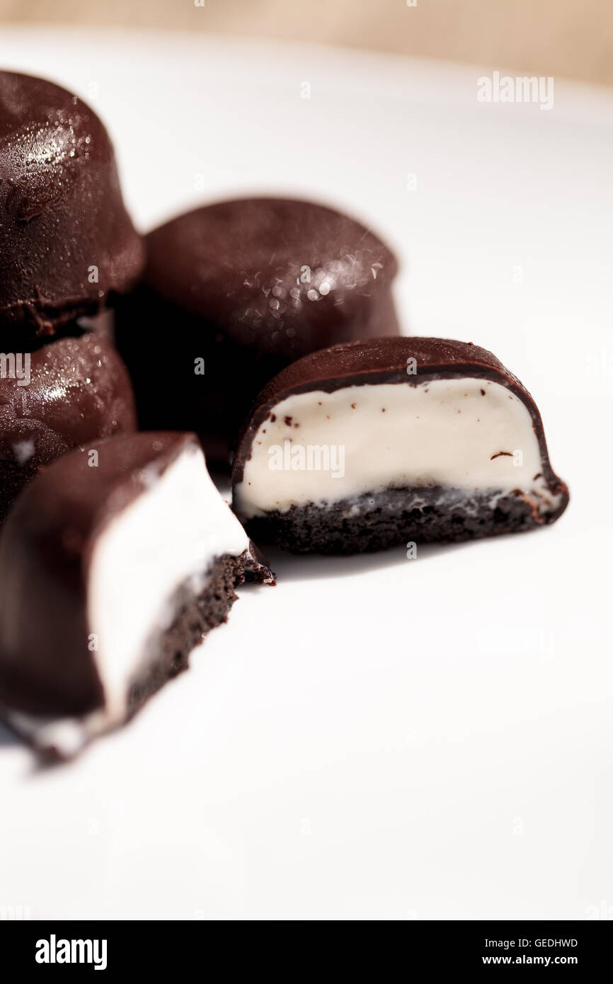 Vanilla ice cream bonbons covered in chocolate for desert on a white