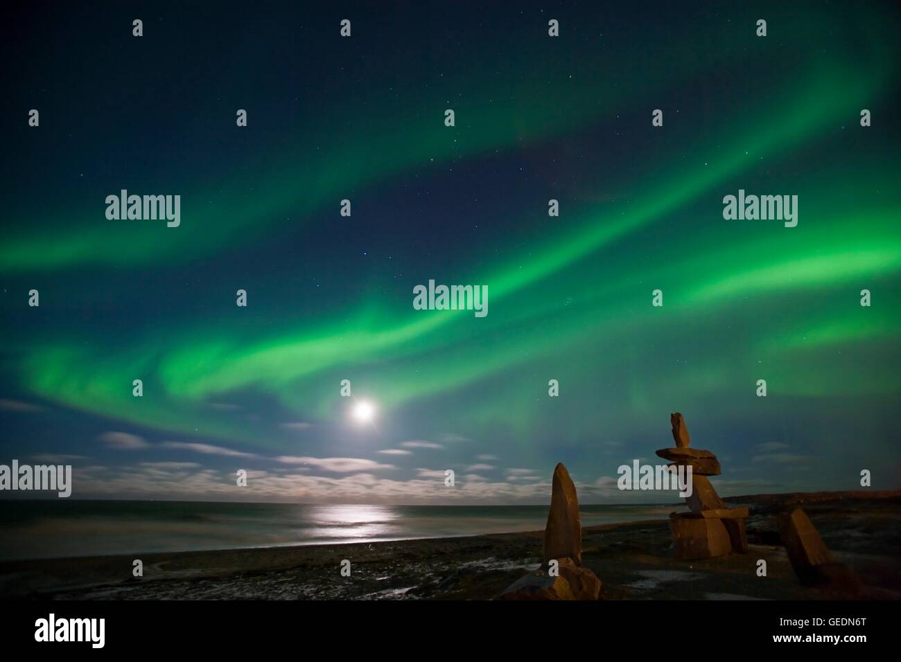 geography / travel, Canada, Manitoba, Churchill, Northern Lights, Aurora borealis, above an inukshuk in the town of Churchill with a bright moon above Hudson Bay, Manitoba, Stock Photo