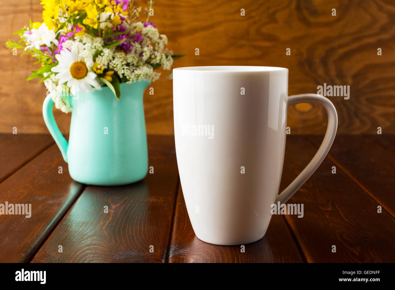 Coffee mug mockup with mint green flowerpot. Coffee cup mock-up for brand promotion.  Empty mug mockup for design presentation. Stock Photo