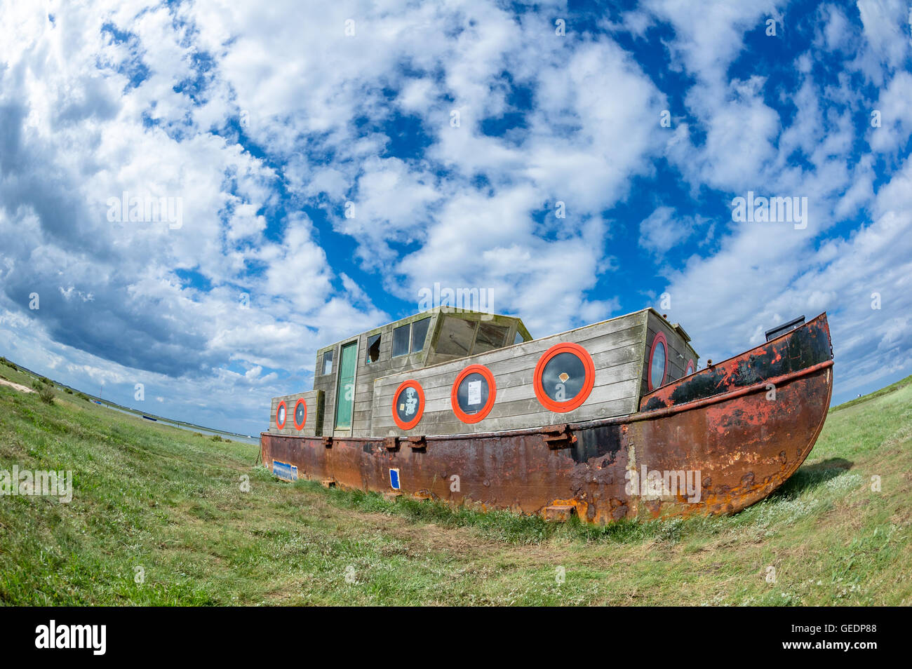 Rusting iron barge, beached on the mud banks at Blakeney, Norfolk, England. Stock Photo