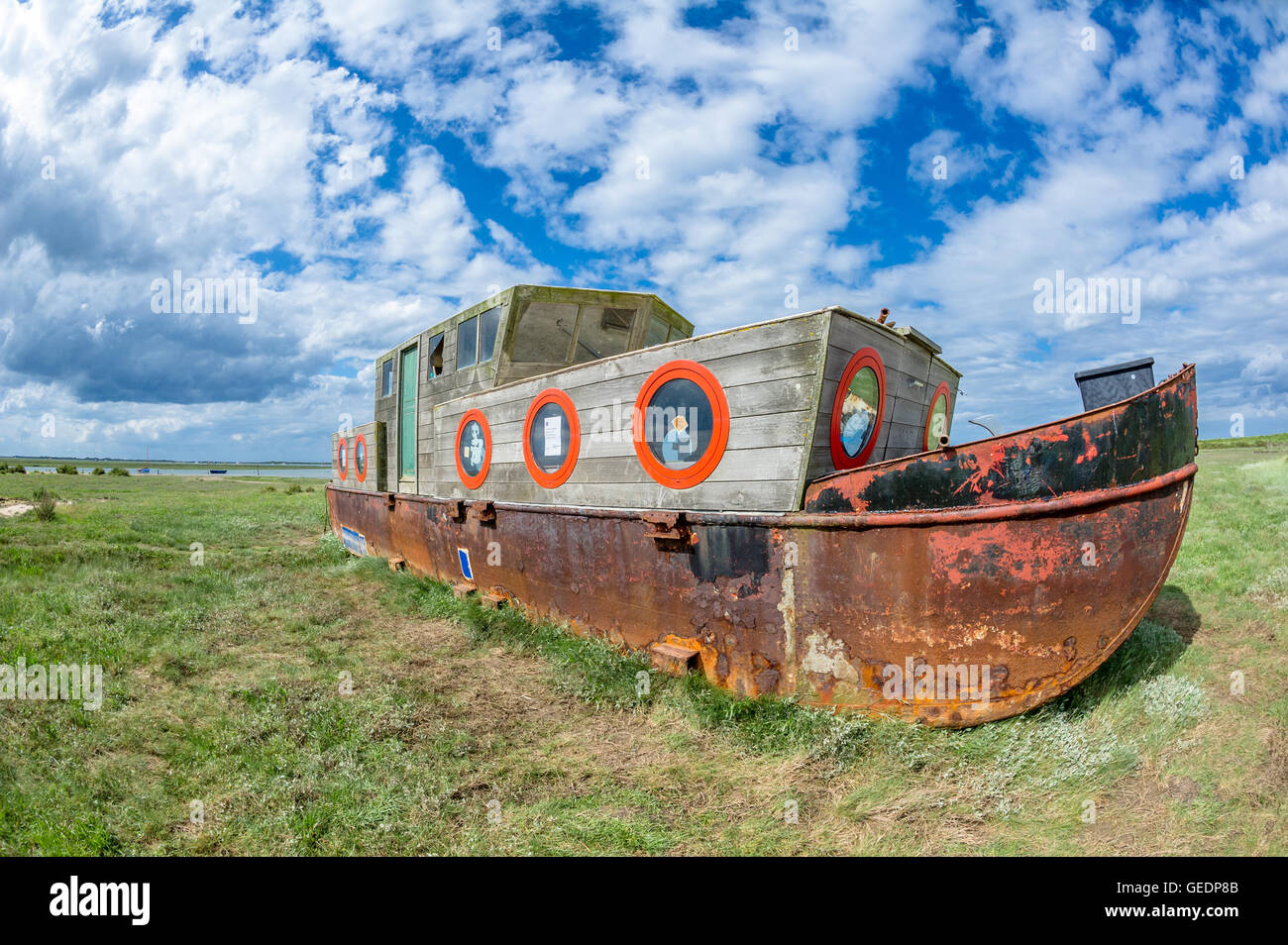 Rusting iron barge, beached on the mud banks at Blakeney, Norfolk, England. Stock Photo
