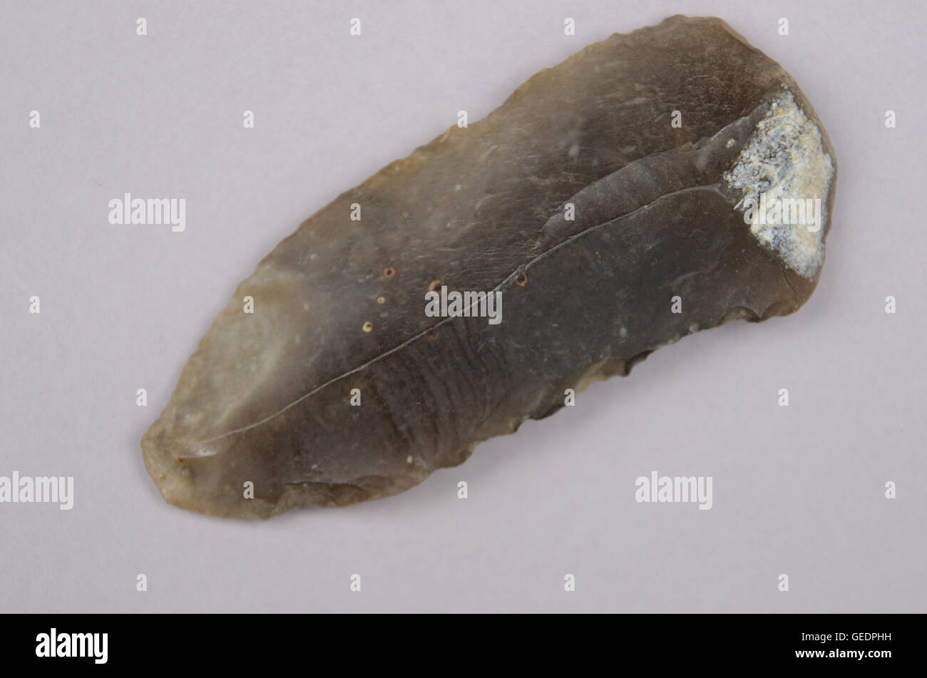 Stone age arrowhead seen as isolated object. Length is 71 mm or 2 3/4' Stock Photo