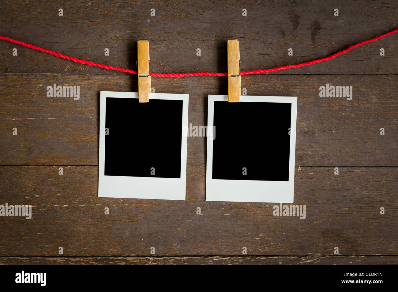 two blank photo frame hanging on wood background with space Stock Photo