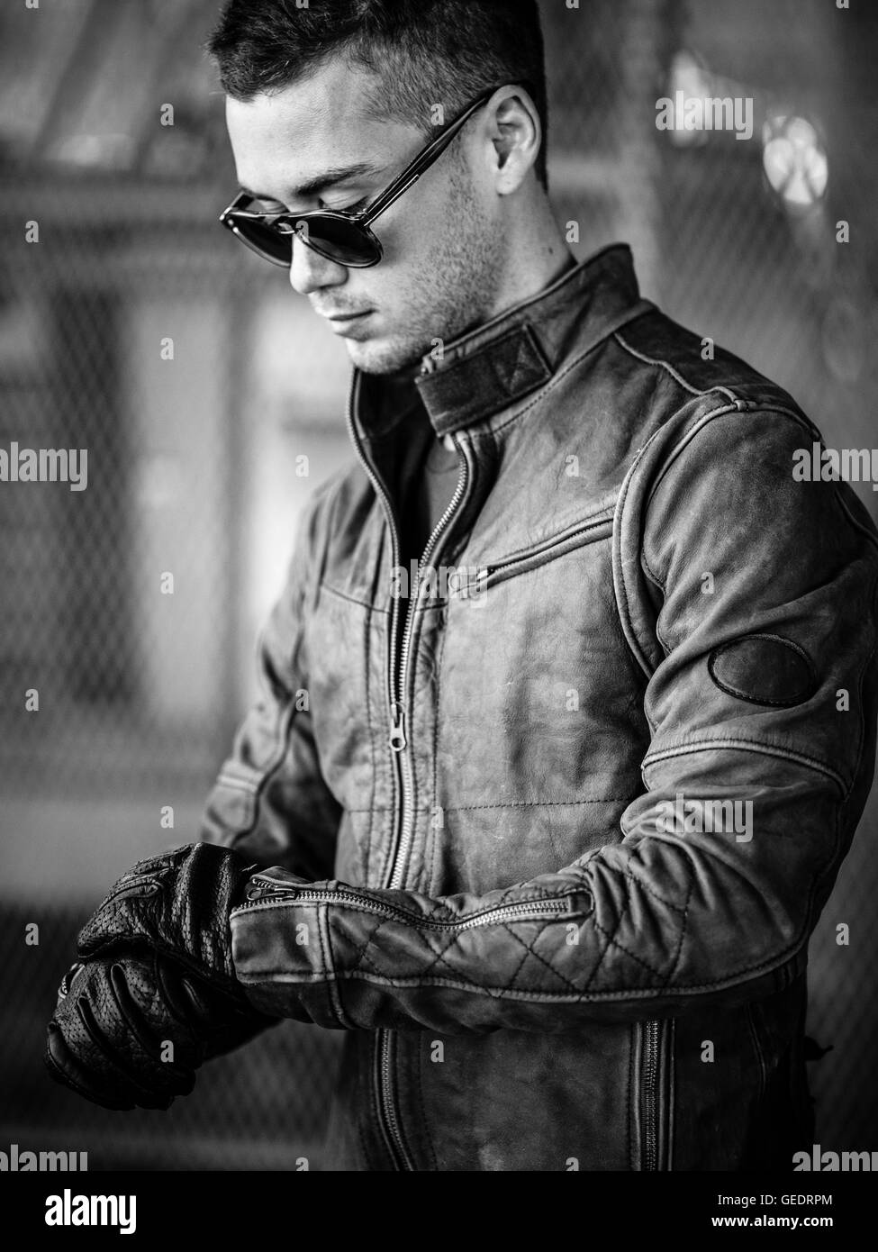 Portrait of Young Adult Man Wearing Sunglasses and Leather Jacket Stock Photo