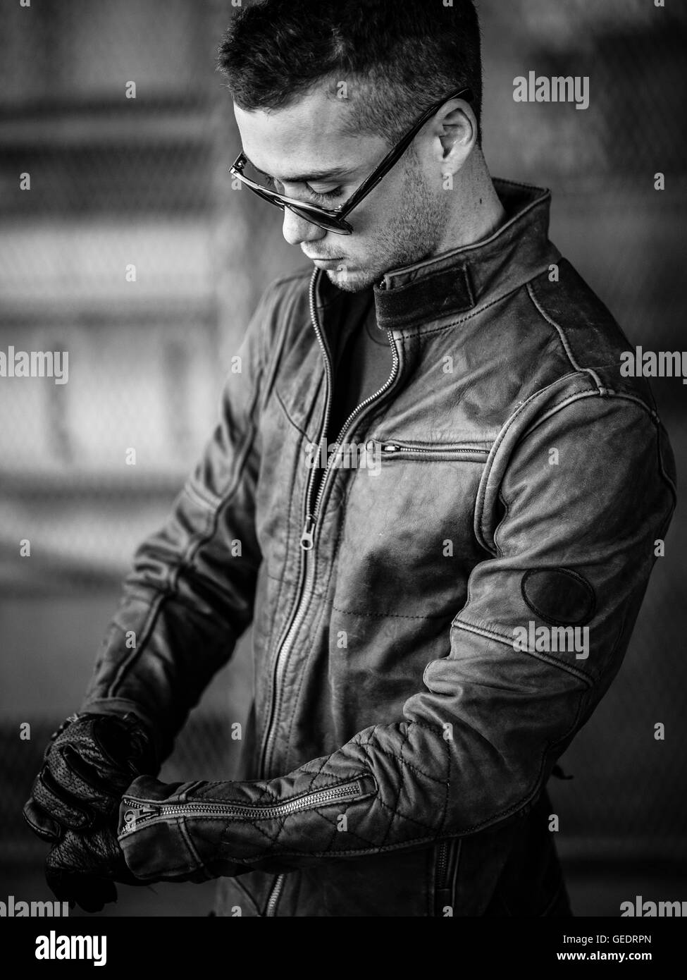 Portrait of Young Adult Man Wearing Sunglasses and Leather Jacket Stock Photo