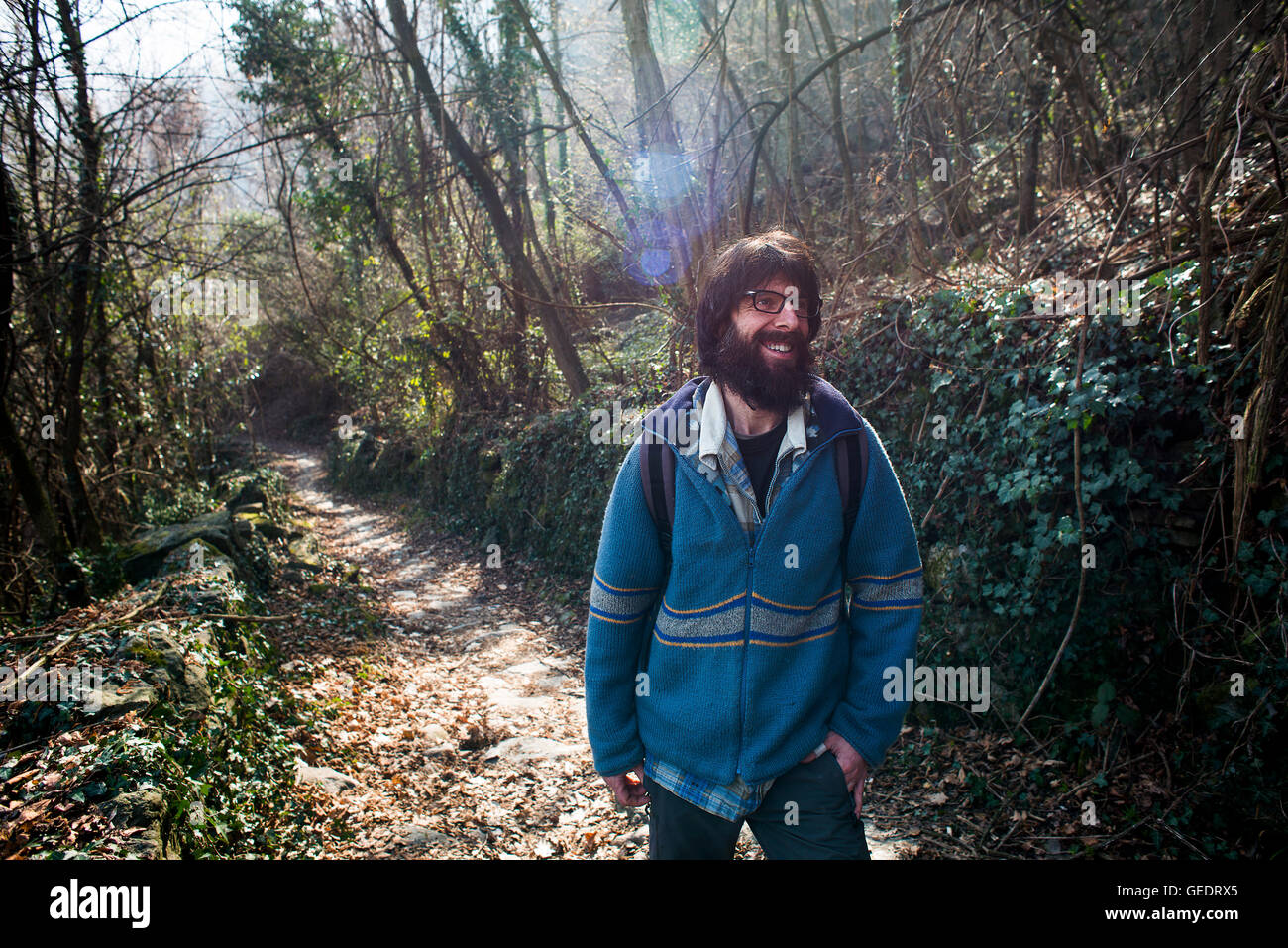 Smiling Man Standing on Wooded Path Stock Photo