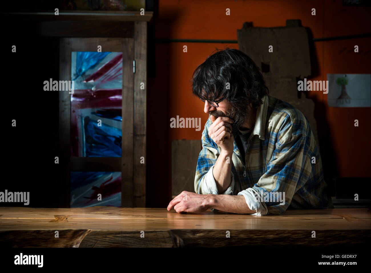 Contemplative Man Leaning on Table Stock Photo