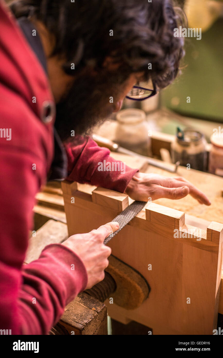 Woodworker Filing Dovetails in Piece of Wood, Close-Up Stock Photo