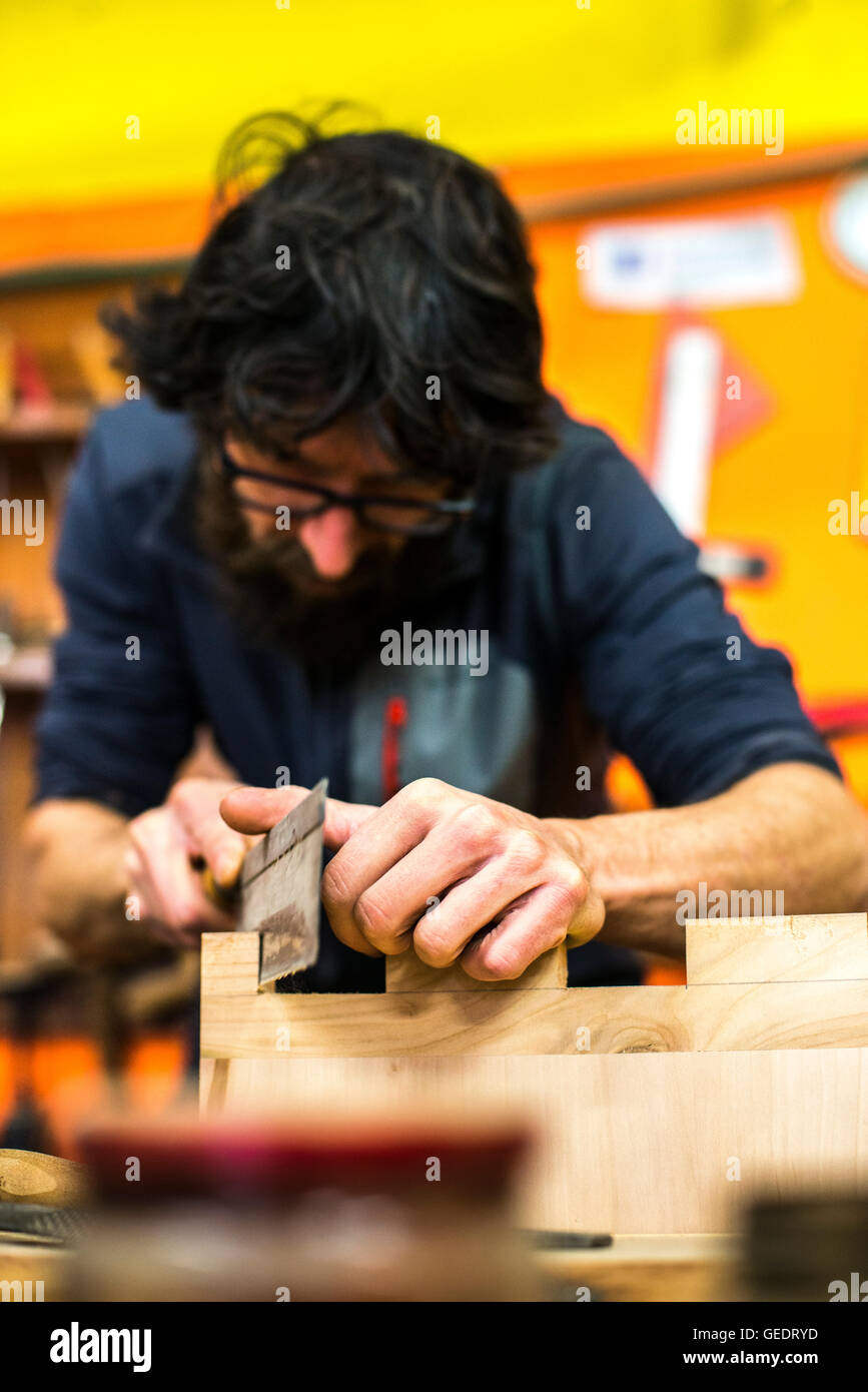 Woodworker Using Hand Saw in Workshop Stock Photo