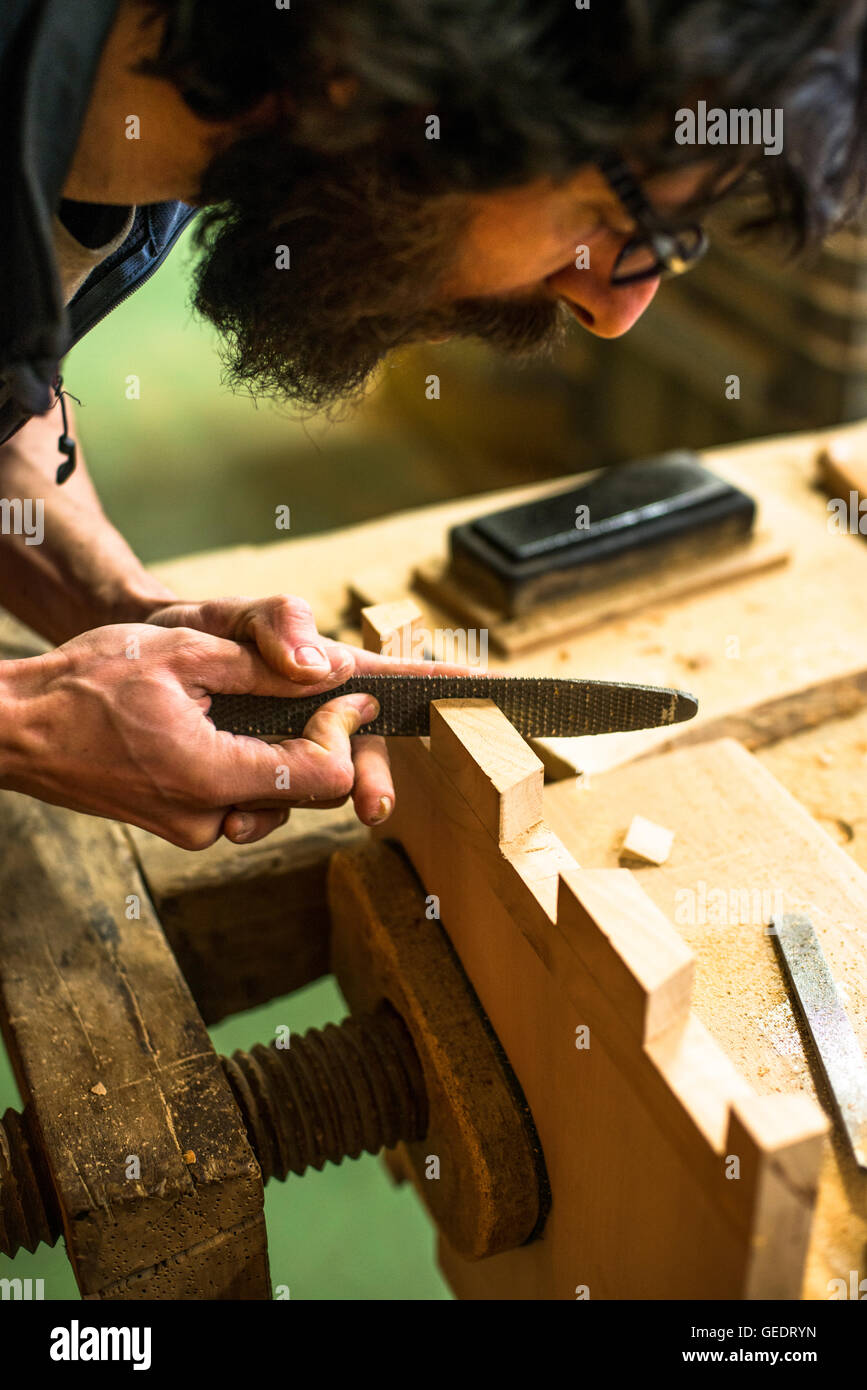 Woodworker Using Rasp on Piece of Wood, High Angle View Stock Photo