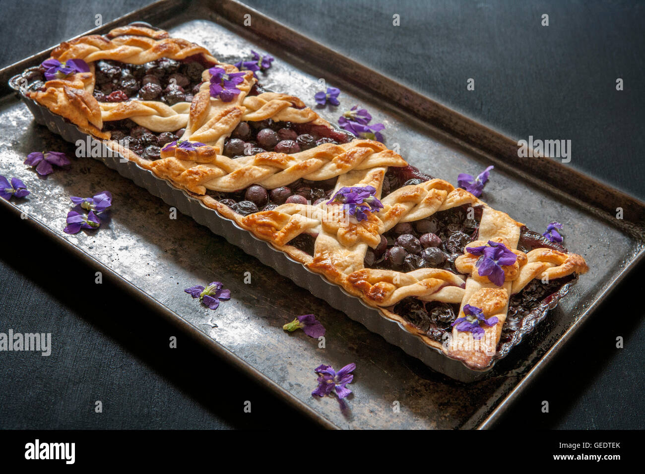 Baked Blueberry Tart with Edible Flowers Stock Photo