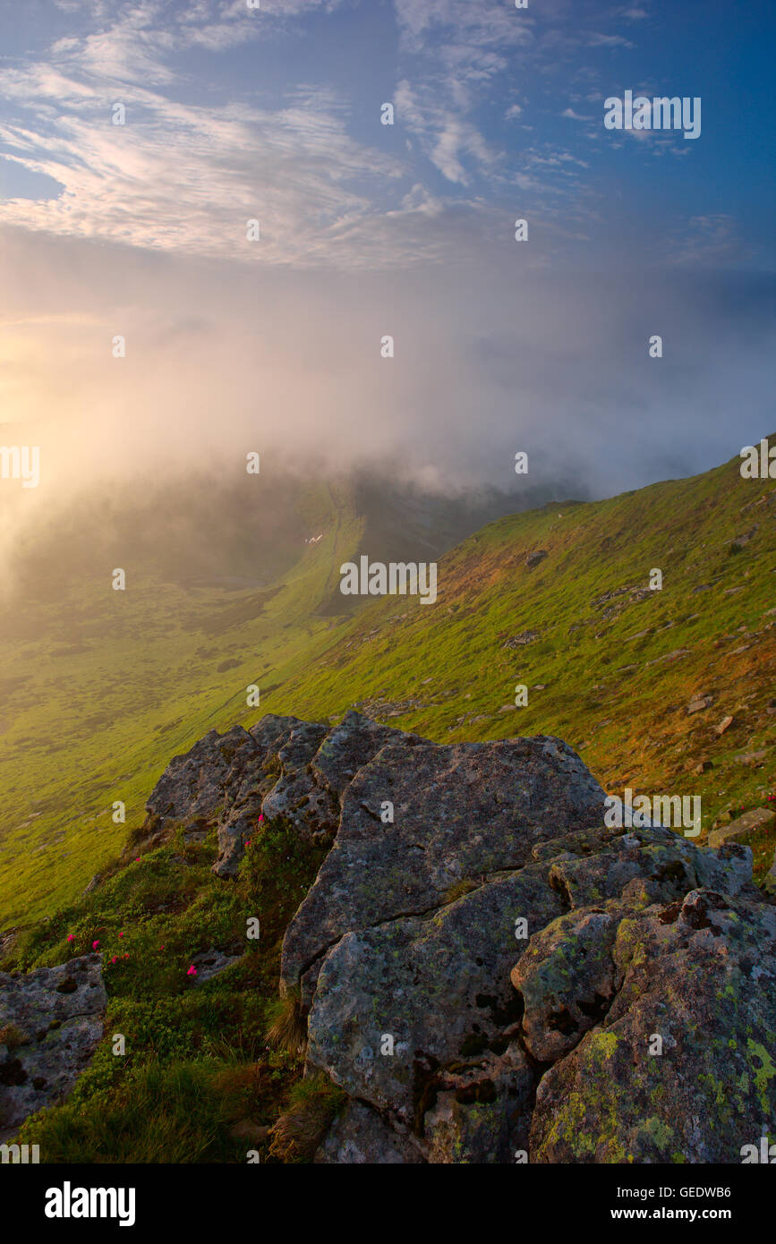 large flat stone relief in the foreground at dawn. Carpathian mountains.drama a morning light Stock Photo