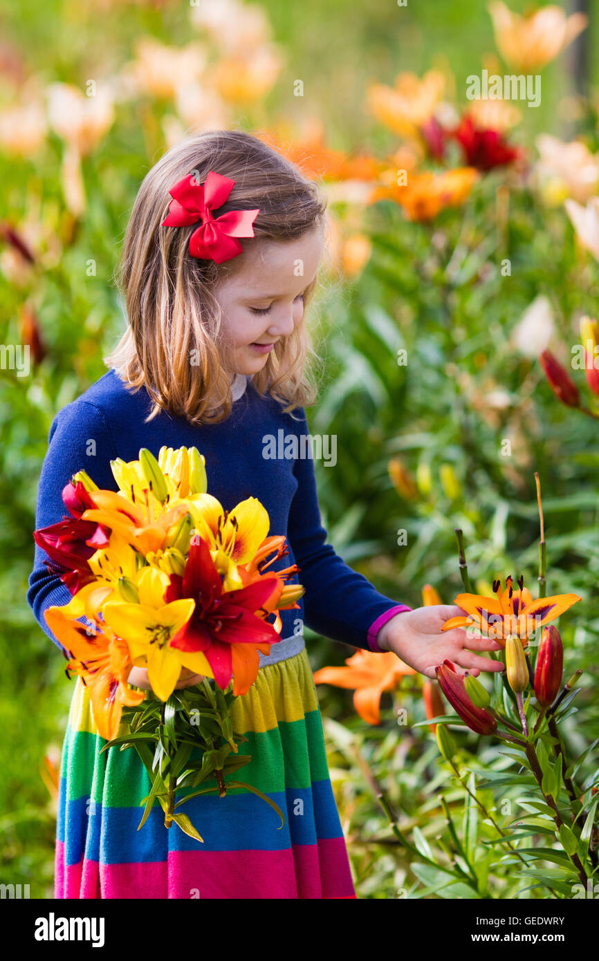 cute-little-girl-picking-lily-flowers-in-blooming-summer-garden-child