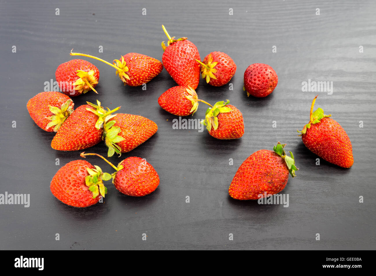Strawberries on black background Stock Photo - Alamy