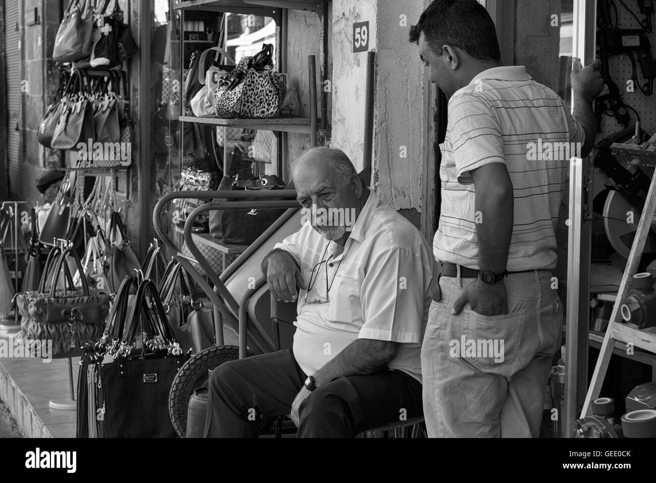 Two men in conversation, Arasta Sokagi, North Nicosia, Nothern Cyprus: the heart of North Nicosia's bazaar area: black and white version Stock Photo
