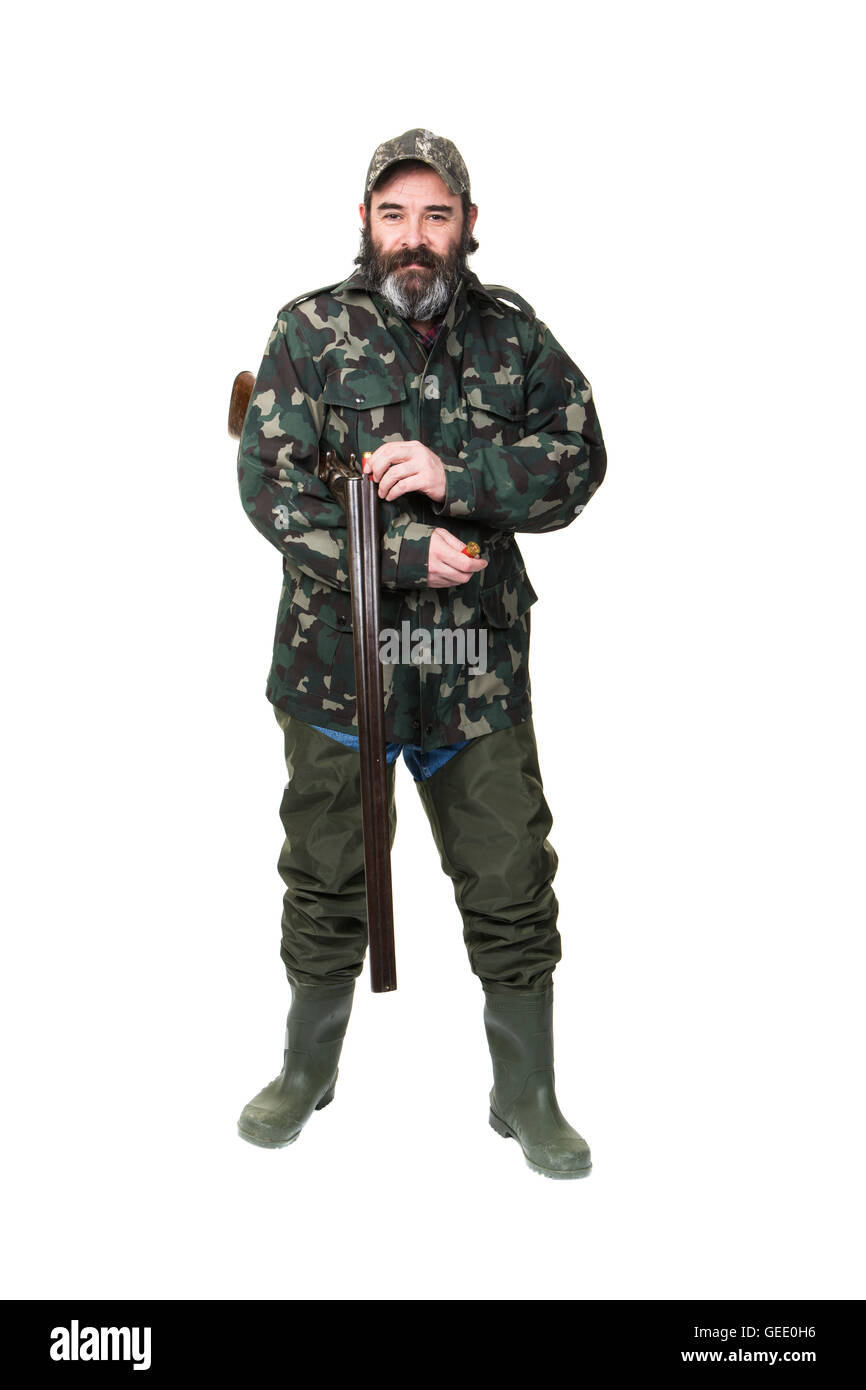 A duck hunter in waders and camo loading a double barreled shotgun on a white background. Stock Photo