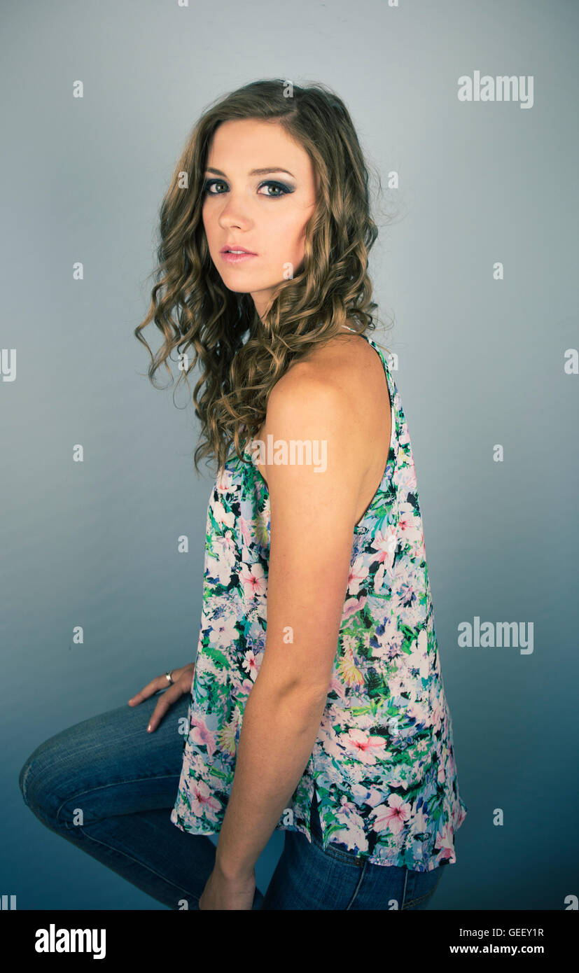 Beautiful young woman wearing jeans on blue background Stock Photo - Alamy