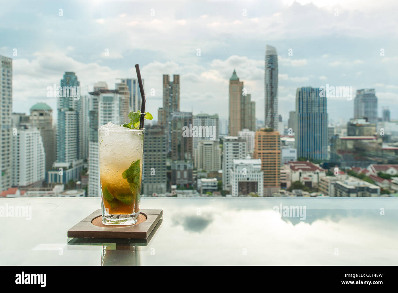 Mojito cocktail on table in rooftop bar with Bangkok city view point in