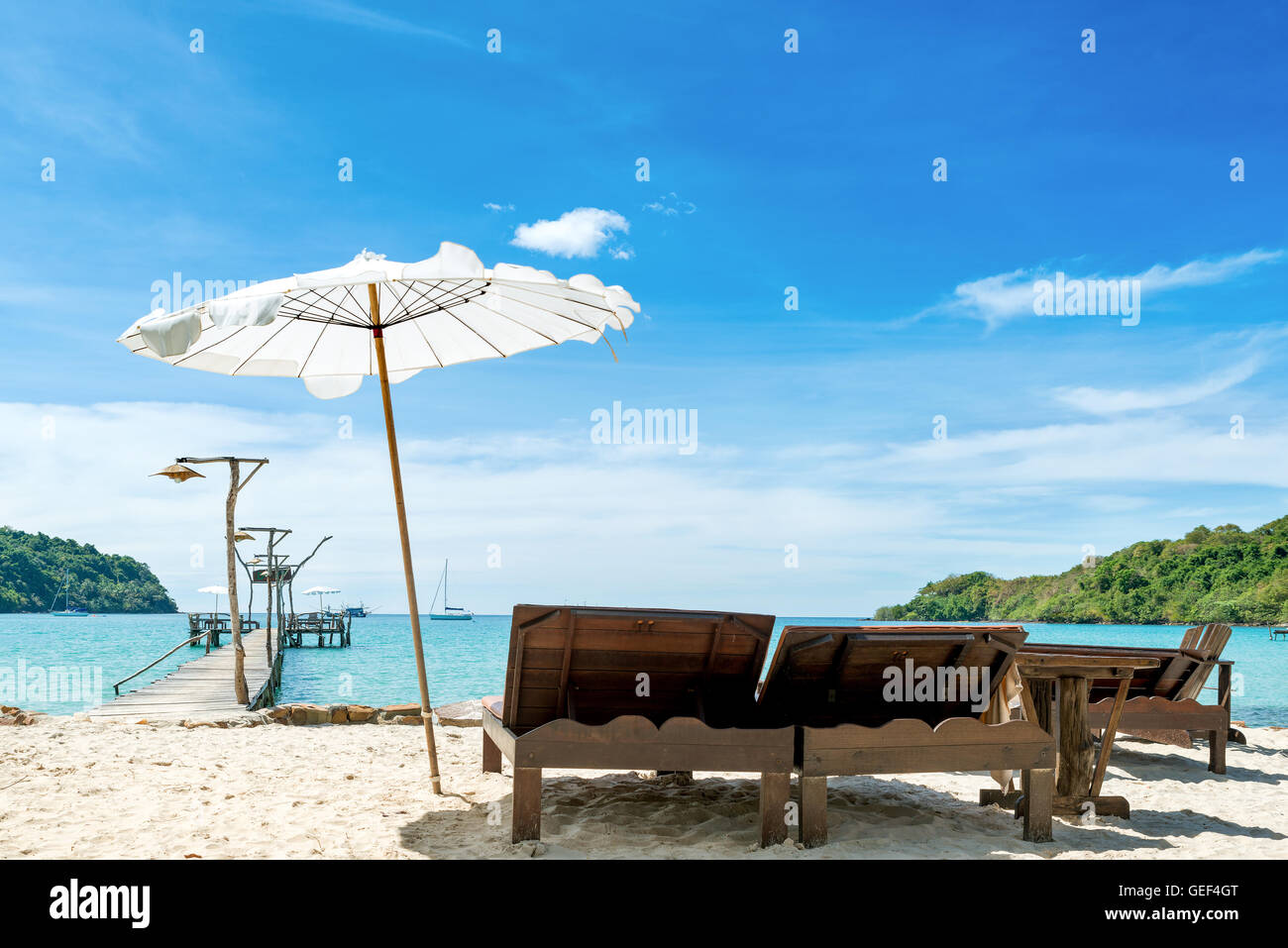 Summer, Travel, Vacation and Holiday concept - Beach chairs with umbrella and beautiful sand beach on hotel beach lounge Stock Photo