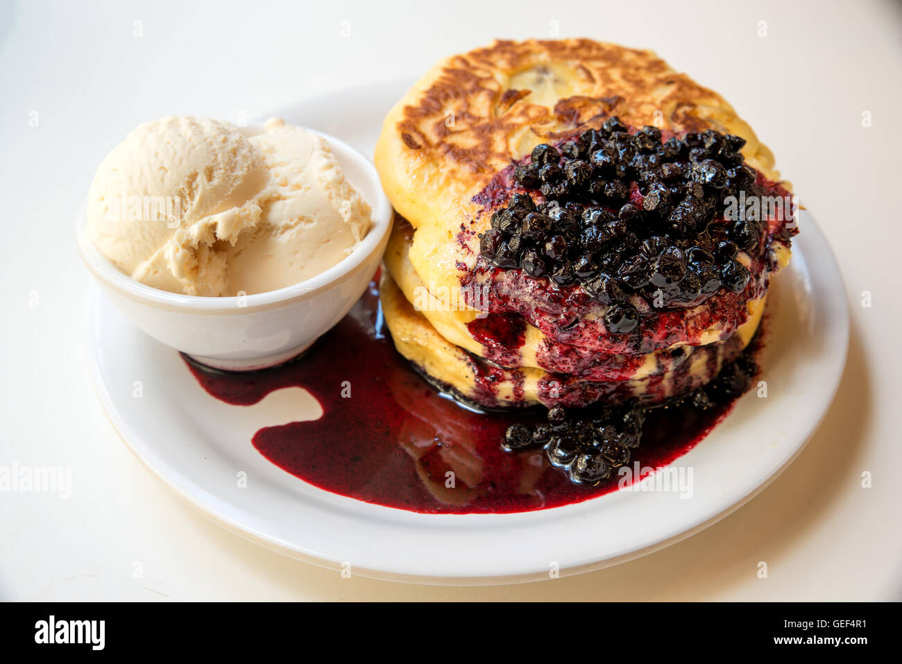 Freshly homemade desserts pancakes with vanilla icecream and blueberry topping on pancakes. Stock Photo