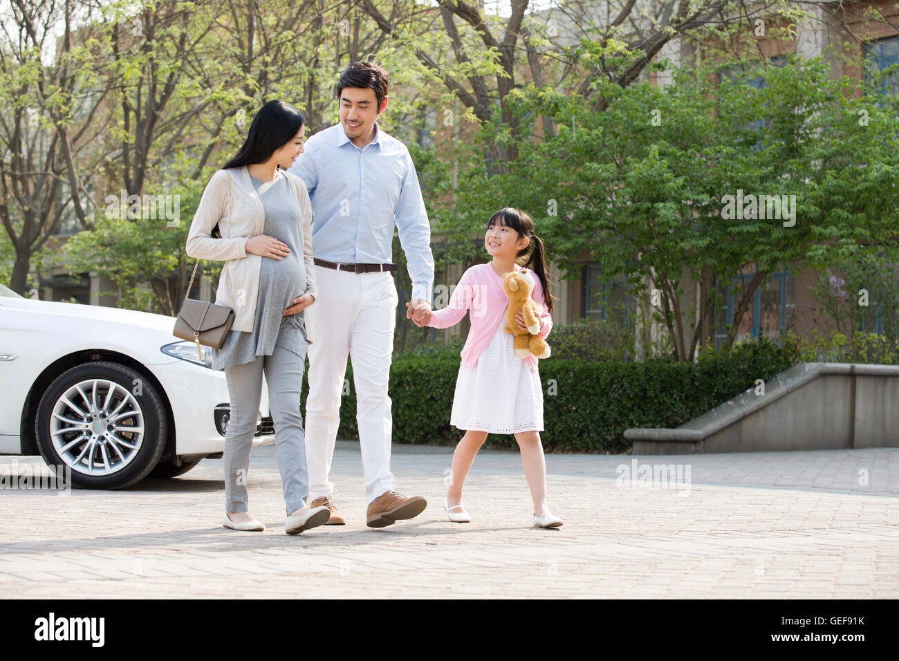 Happy young Chinese family holding hands walking Stock Photo - Alamy