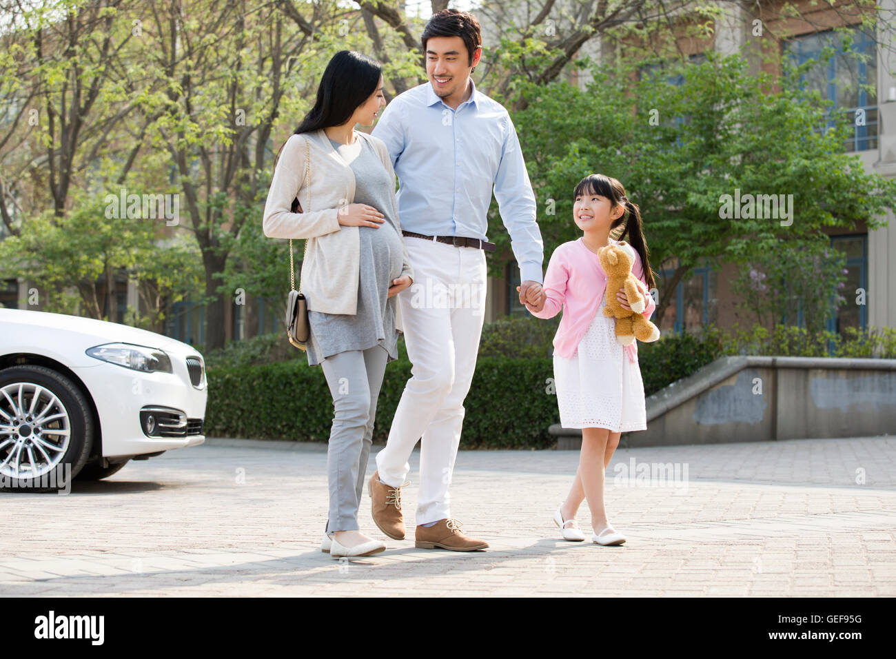 Happy young Chinese family holding hands walking Stock Photo - Alamy