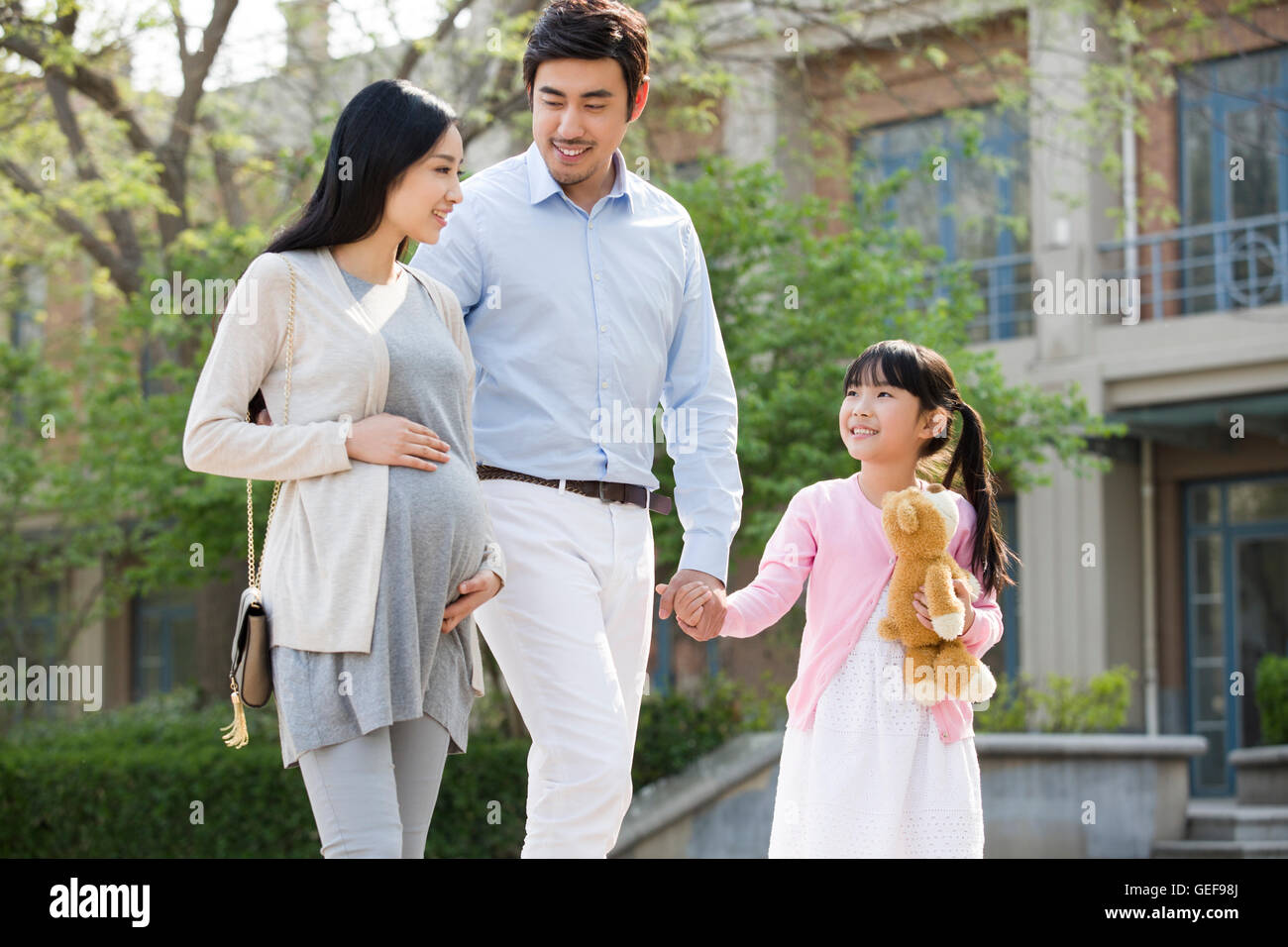 Happy young Chinese family holding hands walking Stock Photo - Alamy
