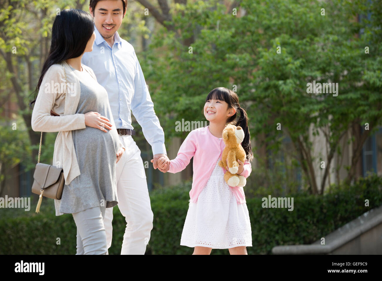 Happy young Chinese family holding hands walking Stock Photo - Alamy