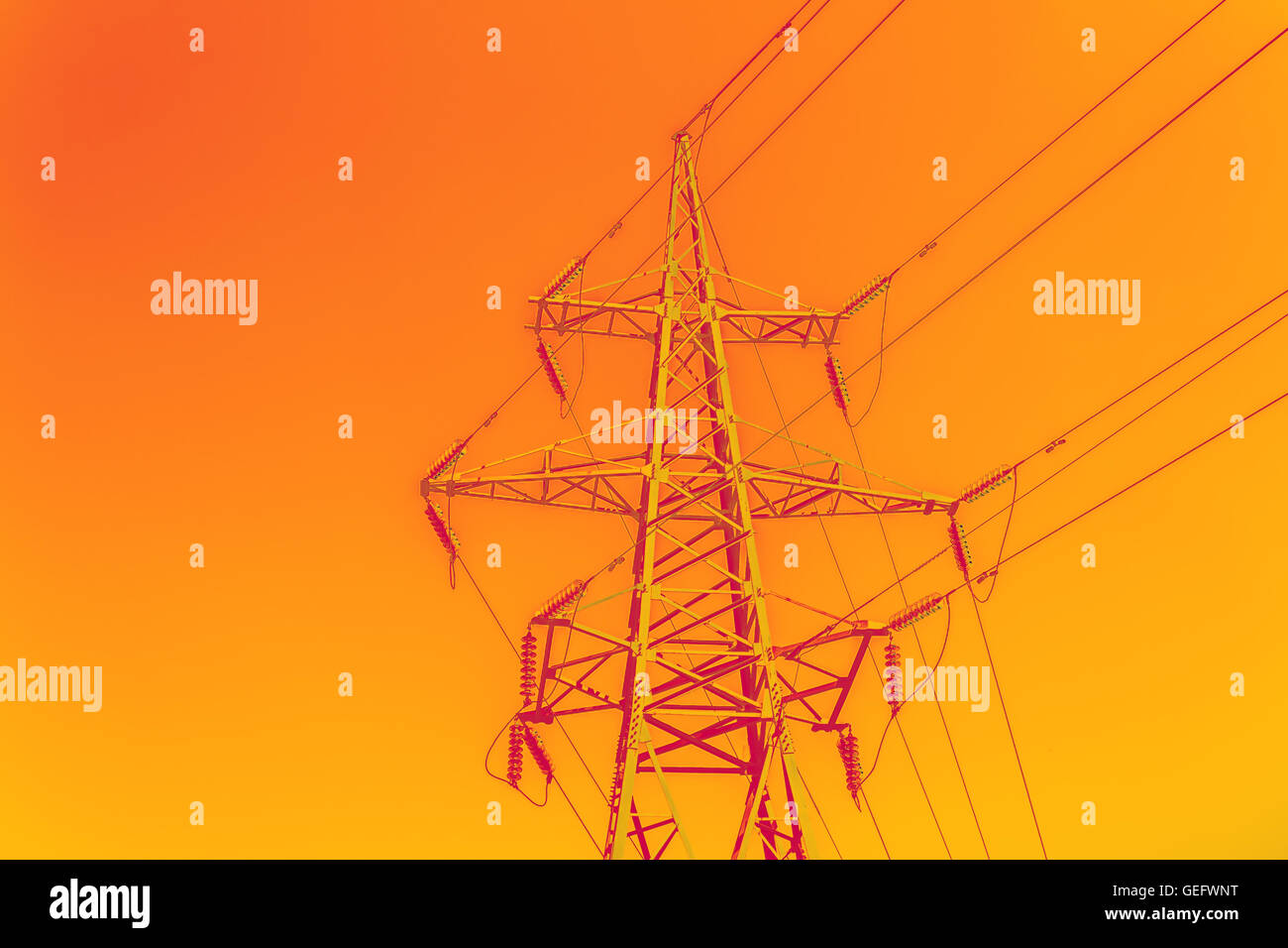 High tower power line on bright orange sky background Stock Photo