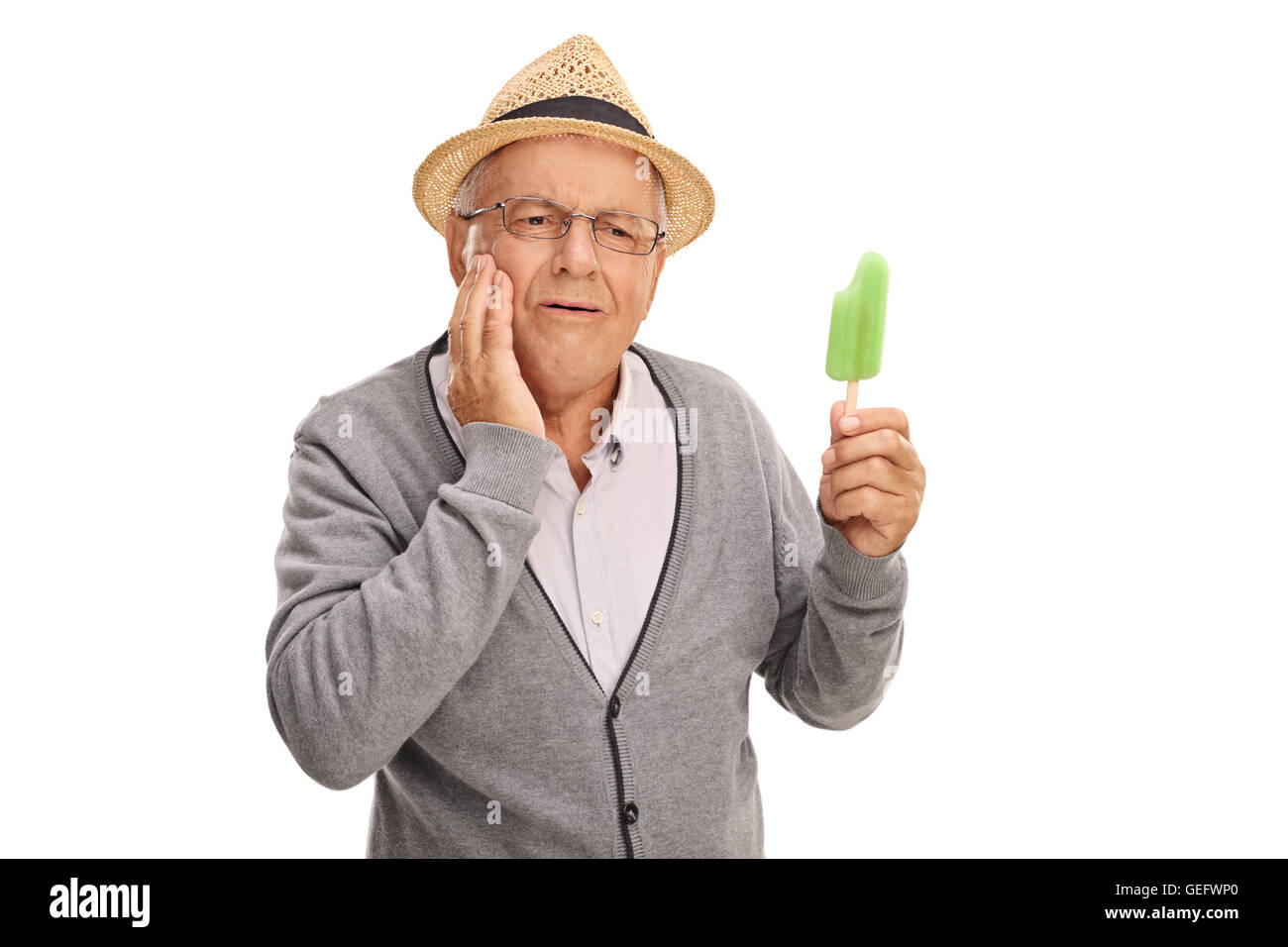 Mature man experiencing a tooth ache from eating ice cream isolated on