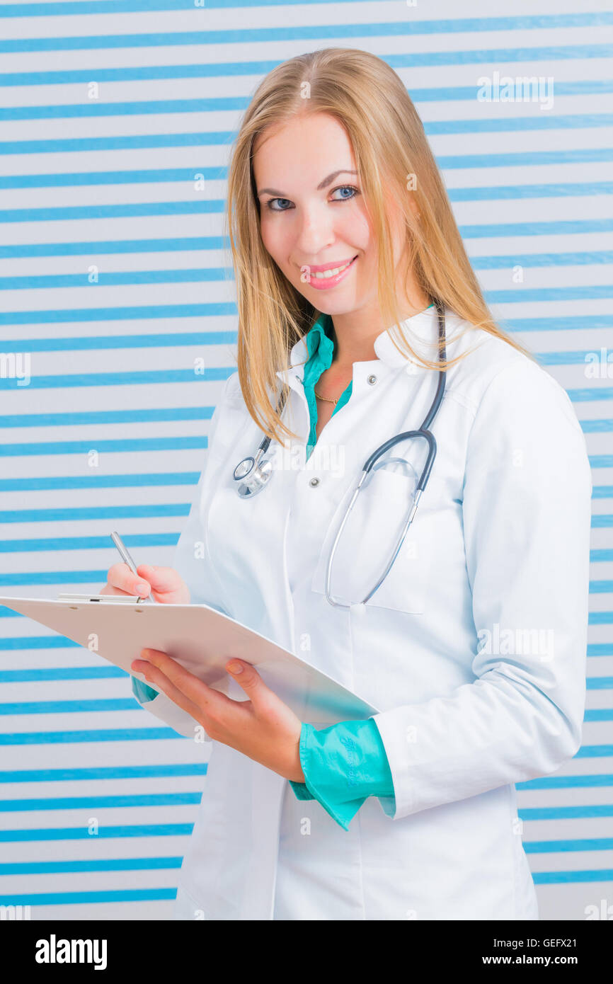 Nurse with long blonde hair and a stethoscope in a uniform smiling at the camera Stock Photo