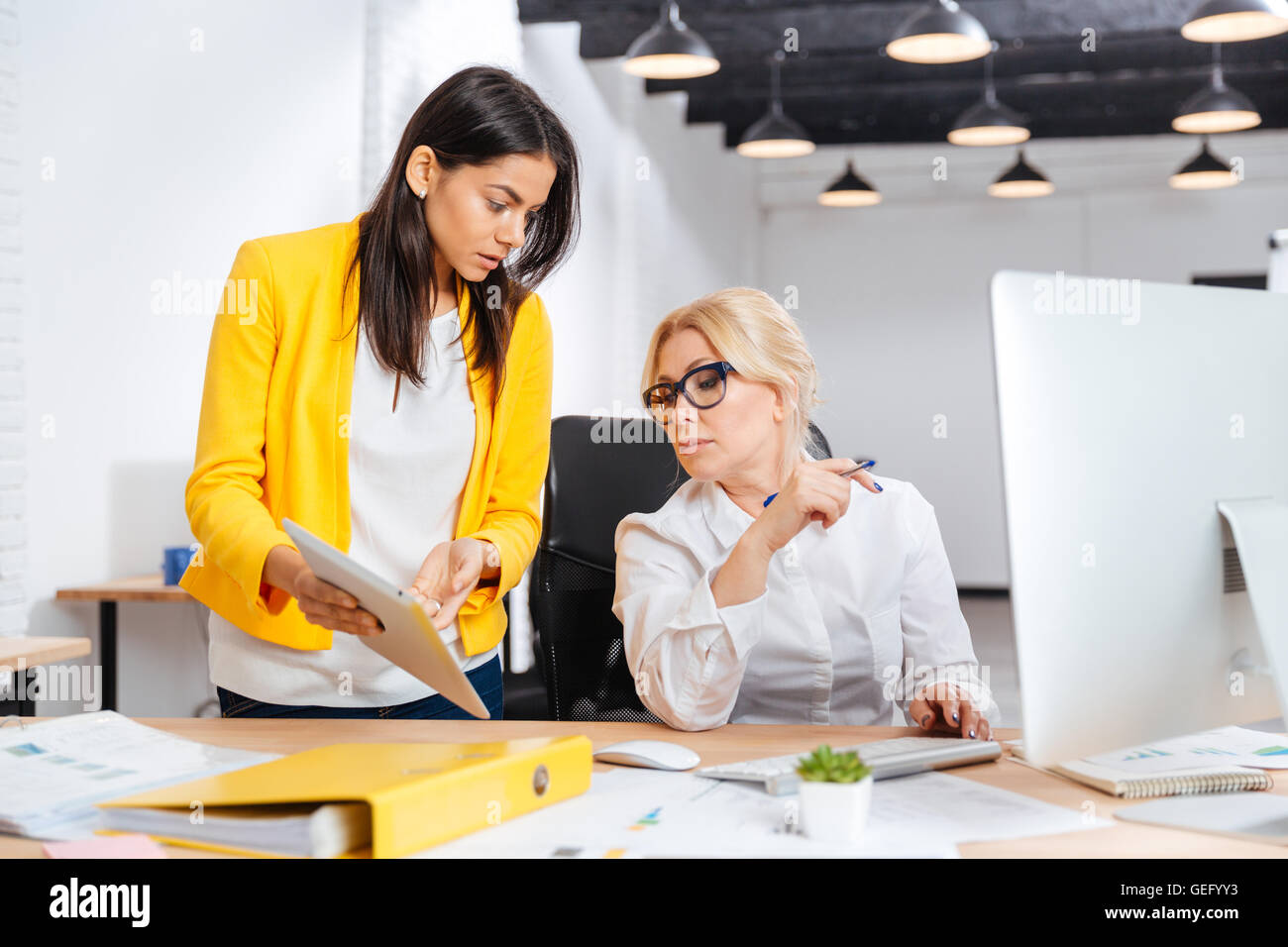 Two businesswomen working together in office Stock Photo - Alamy