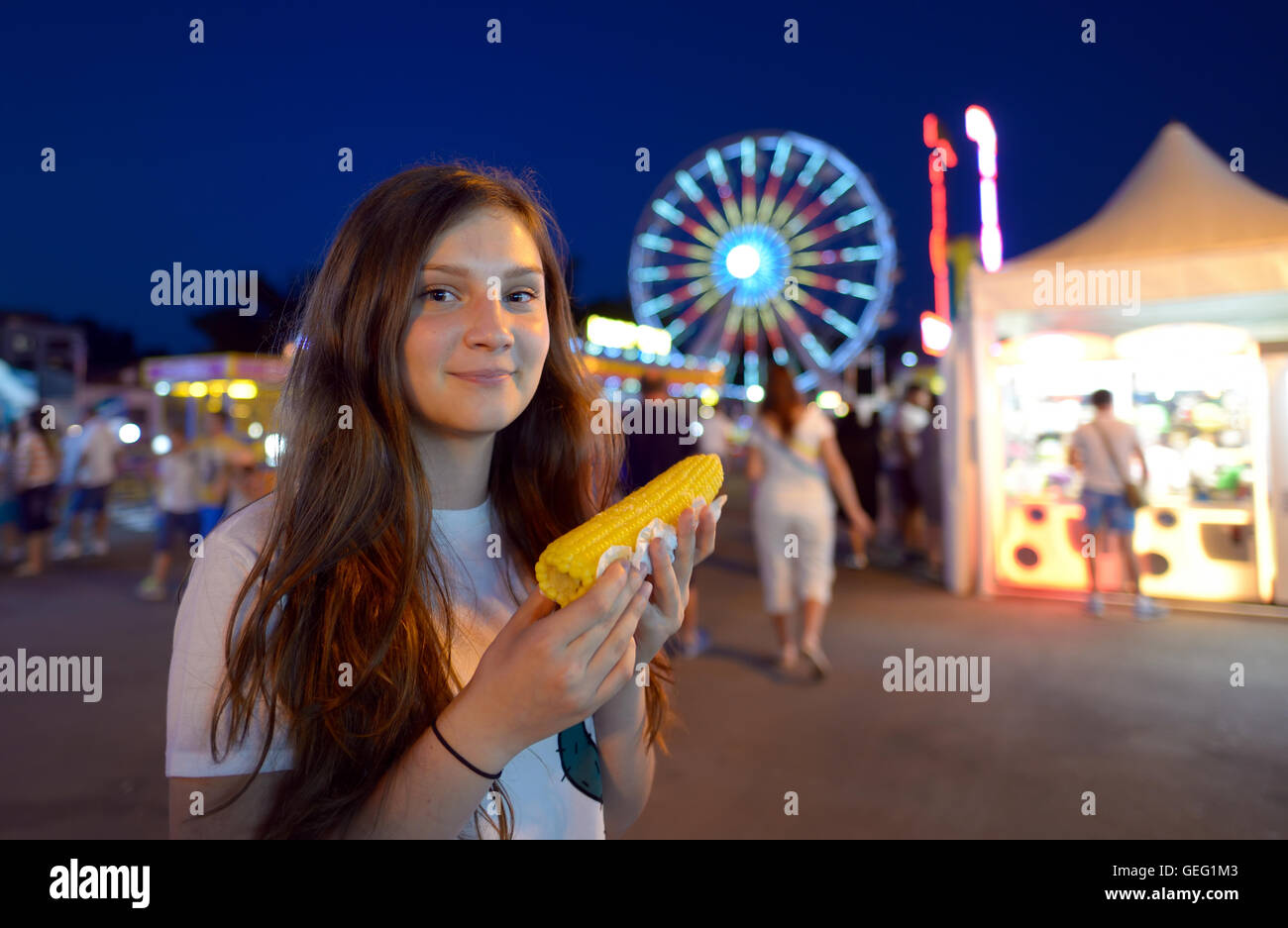 teen girl eating corn in fair Stock Photo
