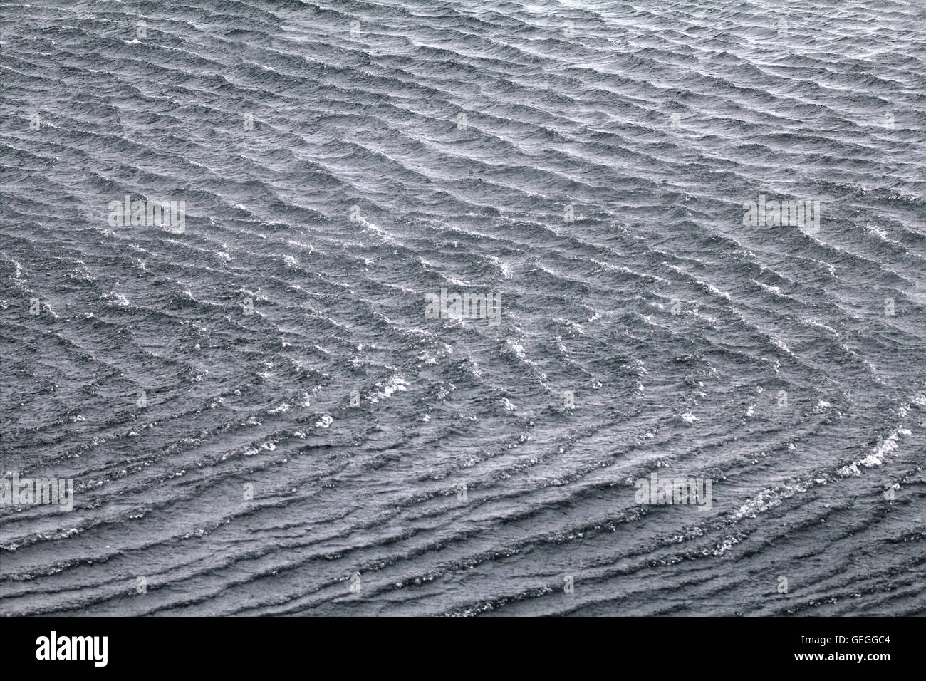 High sharp waves in the Arctic sea. On the horizon of the Northern island of Novaya Zemlya Stock Photo