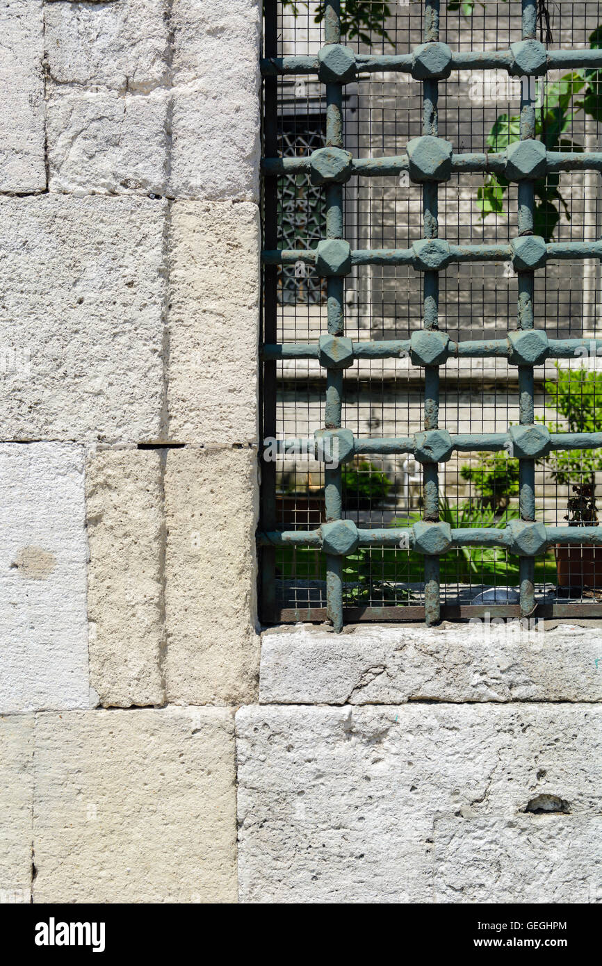 Old stone wall with window and grille Stock Photo