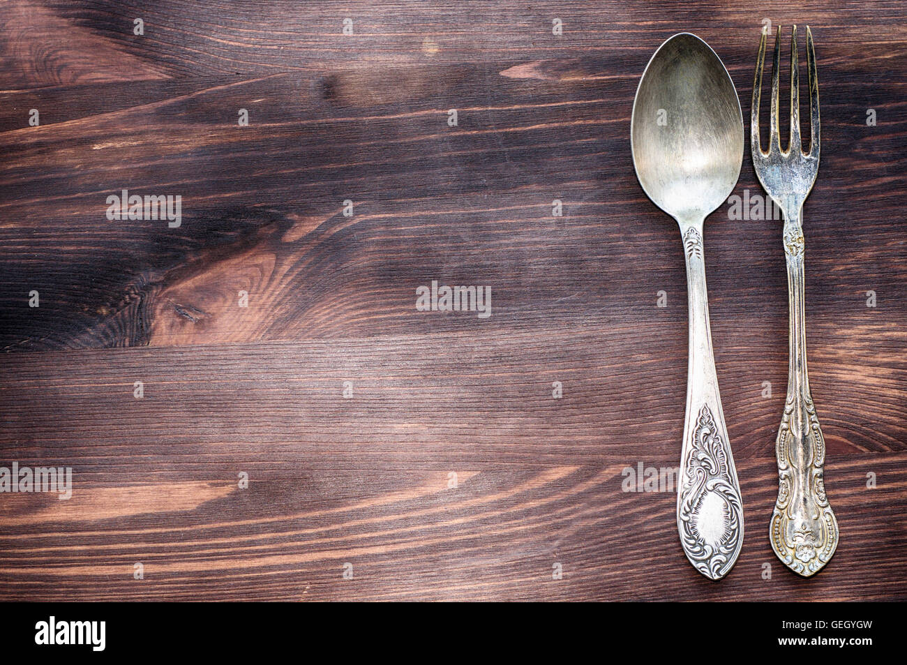 retro brown wooden background with vintage iron fork and spoon Stock
