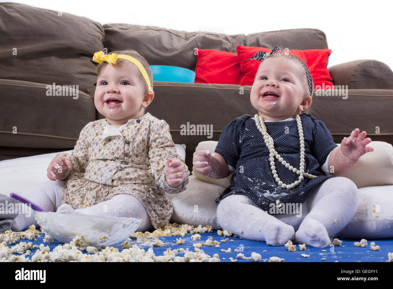 introducing food to baby, happy twin babies making a mess Stock Photo