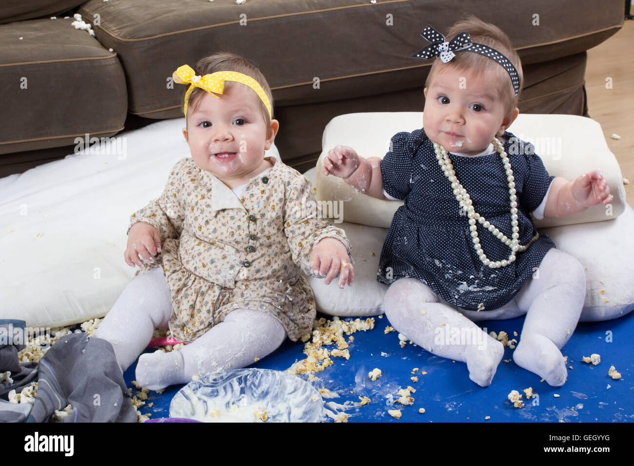 introducing food to baby, happy twin babies making a mess Stock Photo
