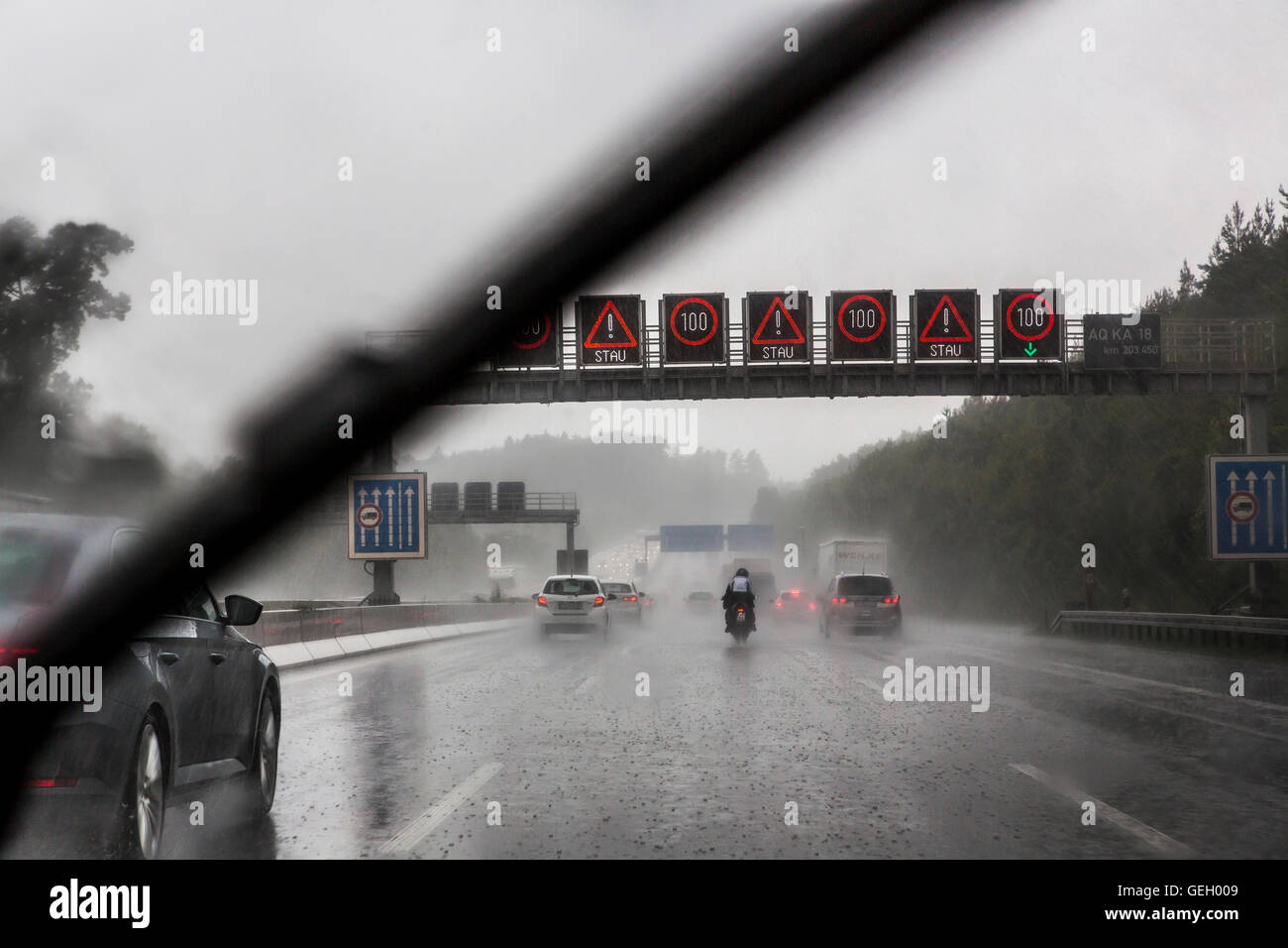 car drives, during a heavy rain storm on a highway, windshield wipers